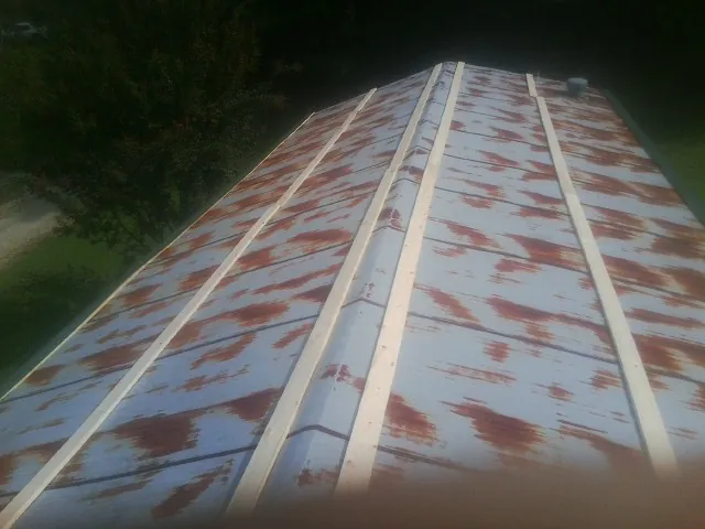 Rusted metal roof panels with new wood purlins before replacement — Storm Damage Roof Repair in Devens by Roofing Brothers