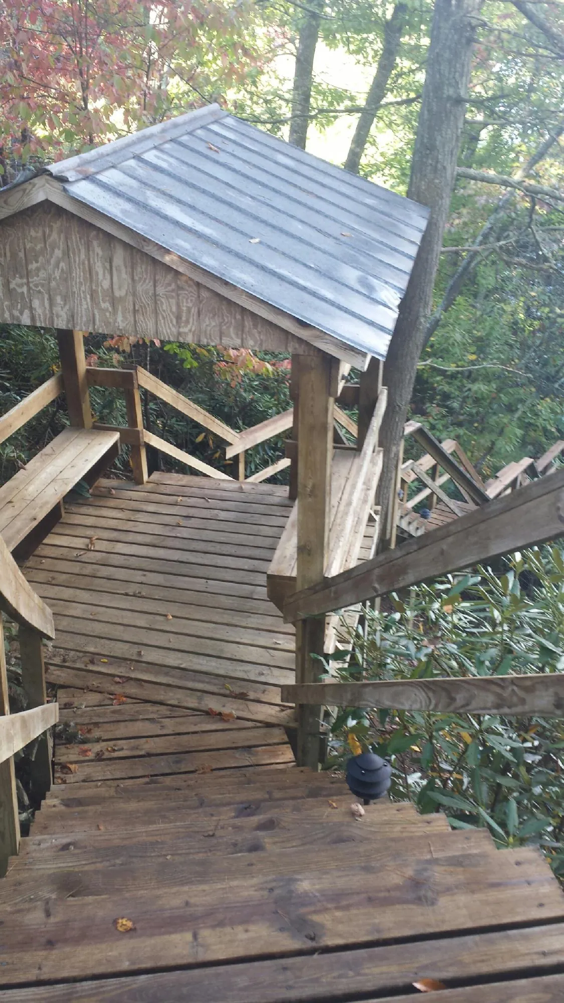 Metal roofed shelter over wooden steps on a wooded walkway — Skylight Repair & Installation work by our crew in Devens