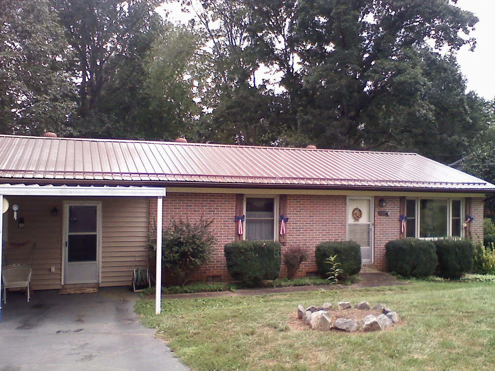 Bronze metal roof and carport on a brick ranch home — Roof Repair work by our crew in Devens